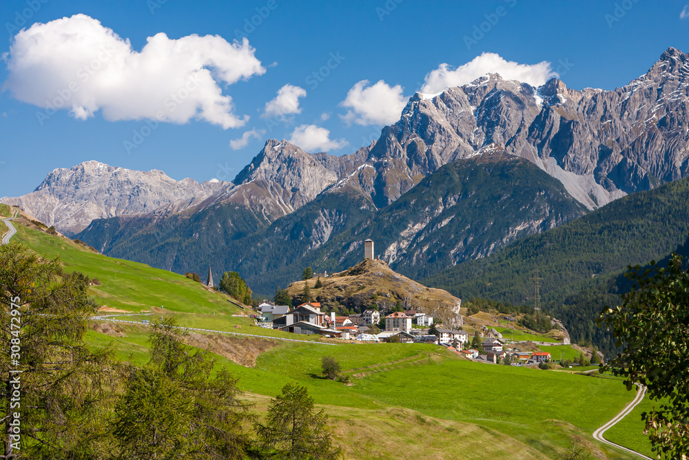 Ardez, a typical eastern Swiss village with Alps and Steinsberg castle in the background.