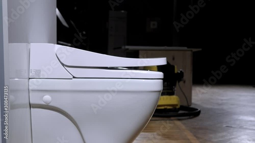 White automatic toilet. Modern technological solution. Raising the lid and rim of the toilet