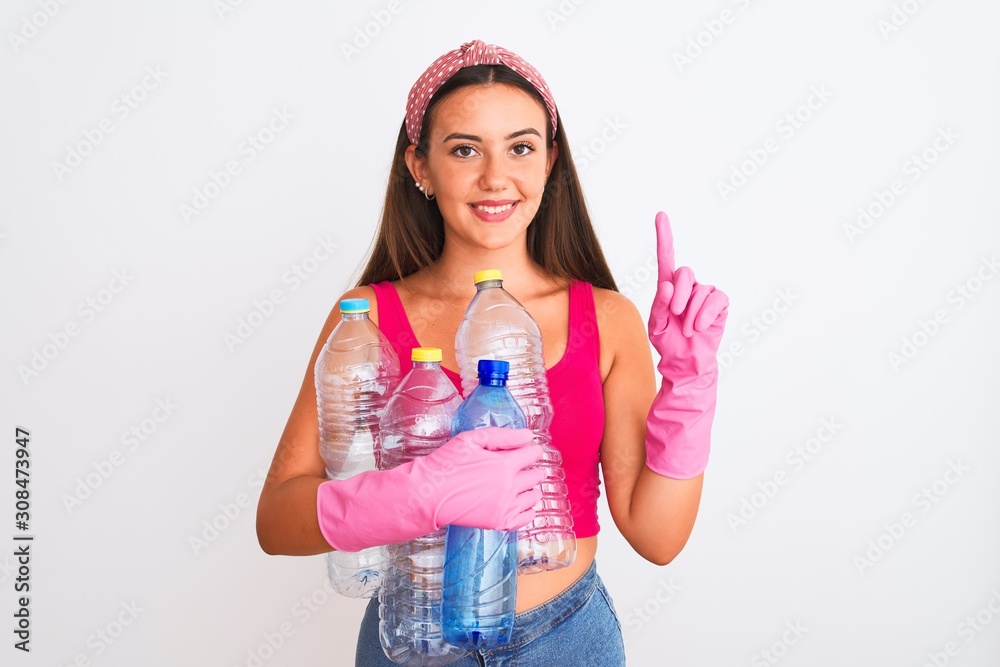 Beautiful girl wearing cleaner gloves recycling plastic bottles over isolated white background surprised with an idea or question pointing finger with happy face, number one Beautiful girl wearing cleaner gloves recycling plastic bottles over isolated white background surprised with an idea or question pointing finger with happy face, number one