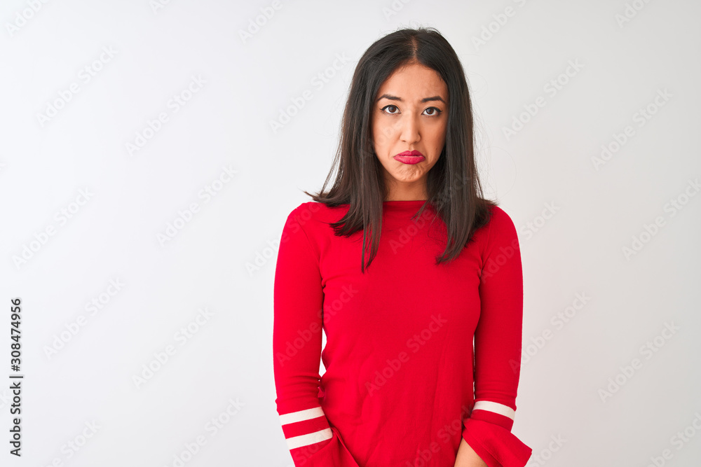 Young beautiful chinese woman wearing red dress standing over isolated white background depressed and worry for distress, crying angry and afraid. Sad expression. Young beautiful chinese woman wearing red dress standing over isolated white background depressed and worry for distress, crying angry and afraid. Sad expression.