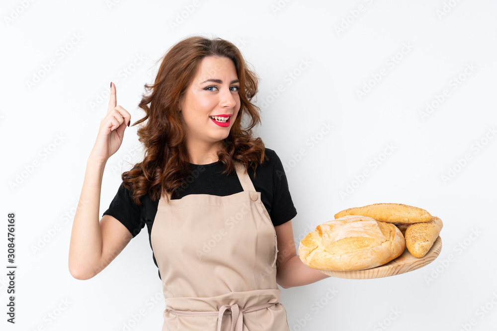 Woman in chef uniform. Female baker holding a table with several breads intending to realizes the solution while lifting a finger up