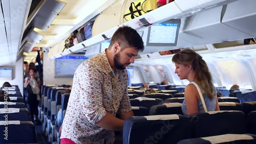 man and woman, passengers are settle down the aircraft, ready for the flight