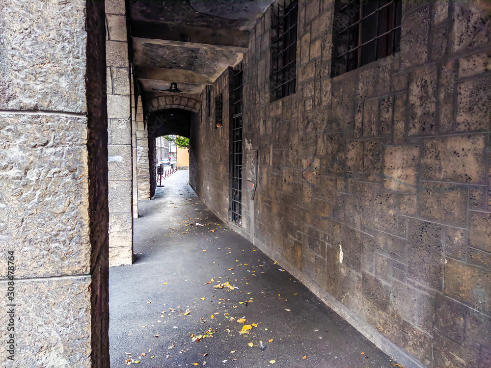 Obraz premium Old and scary looking exterior hallway corridor next to an old building facade with dark and abandoned feeling to it.