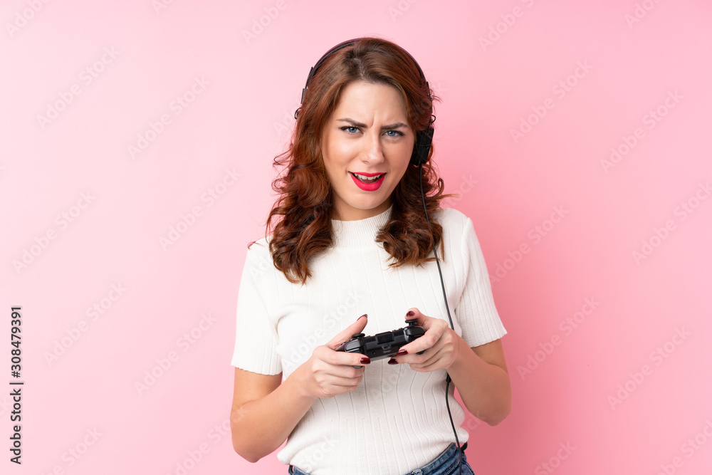 Young Russian woman over isolated pink background playing at videogames Young Russian woman over isolated pink background playing at videogames