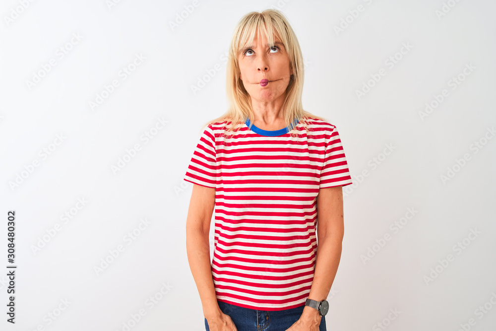 Middle age woman wearing casual striped t-shirt standing over isolated white background making fish face with lips, crazy and comical gesture. Funny expression. Middle age woman wearing casual striped t-shirt standing over isolated white background making fish face with lips, crazy and comical gesture. Funny expression.