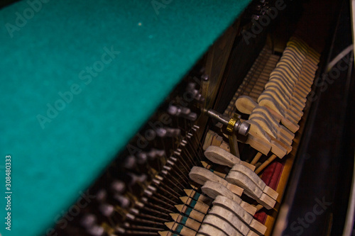 Close up of old broken dusty piano from the inside. Hammers in abandoned piano striking strings. Music playing from the ancient ruined piano. Gavel of the string open mechanism. photo