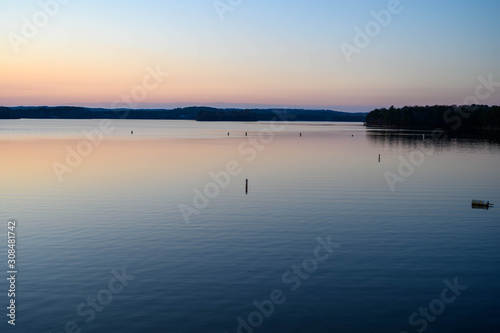 Buoys sticking up in the lake at sunset. With sunset colors reflecting off the still waters of the lake.