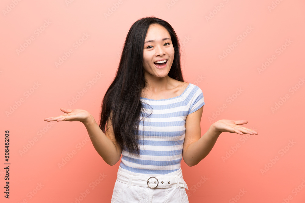Teenager asian girl over isolated pink background with shocked facial expression Teenager asian girl over isolated pink background with shocked facial expression