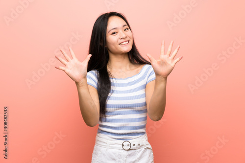 Teenager asian girl over isolated pink background counting ten with fingers