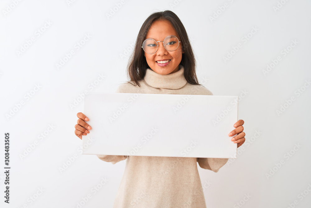 Young beautiful chinese woman wearing glasses holding banner over isolated white background with a happy face standing and smiling with a confident smile showing teeth Young beautiful chinese woman wearing glasses holding banner over isolated white background with a happy face standing and smiling with a confident smile showing teeth