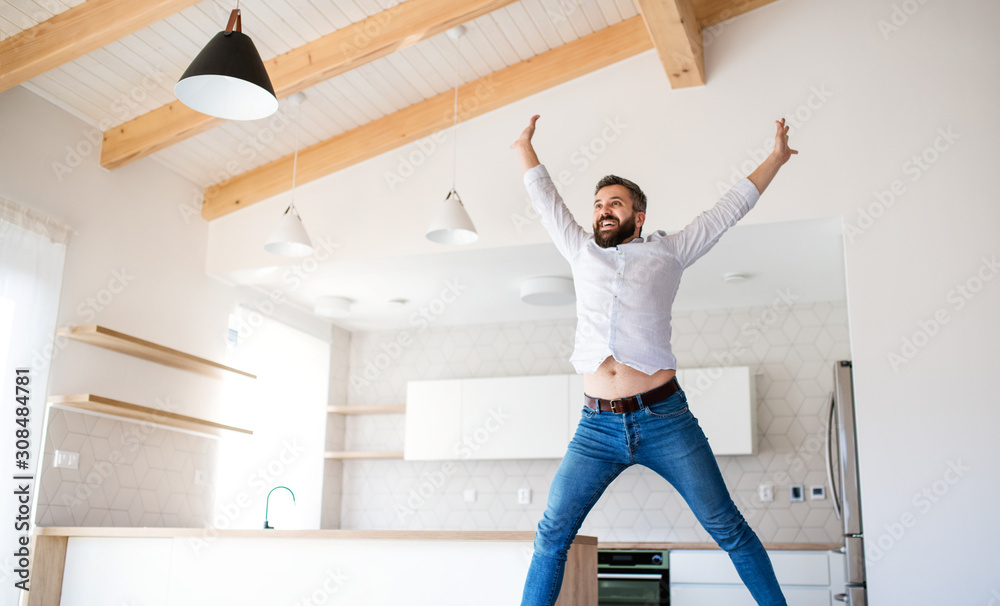 Cheerful mature man moving in new unfurnished house, jumping. Cheerful mature man moving in new unfurnished house, jumping.