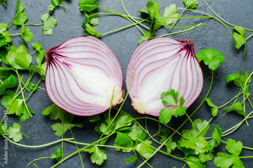 Red onion cut into two halves. Background of parsley leaves. photo