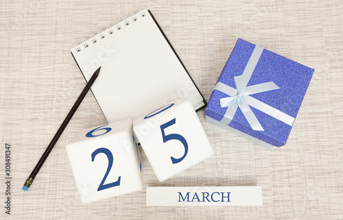 Calendar with trendy blue text and numbers for March 25 and a gift in a box.