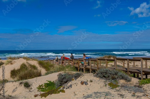 Landscape of a wooden beach with people on it on the beach surrounded by the sea in Portugal photo