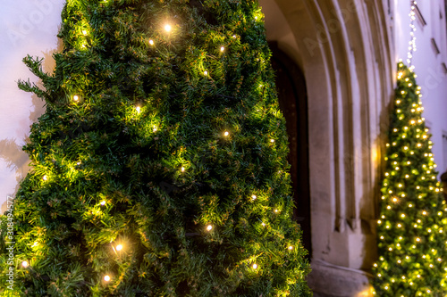 Two trees decorated with light at the entrance to the Christmas markets illuminated by the old town hall of Brno Czech Republic during the classic Christmas markets. photo