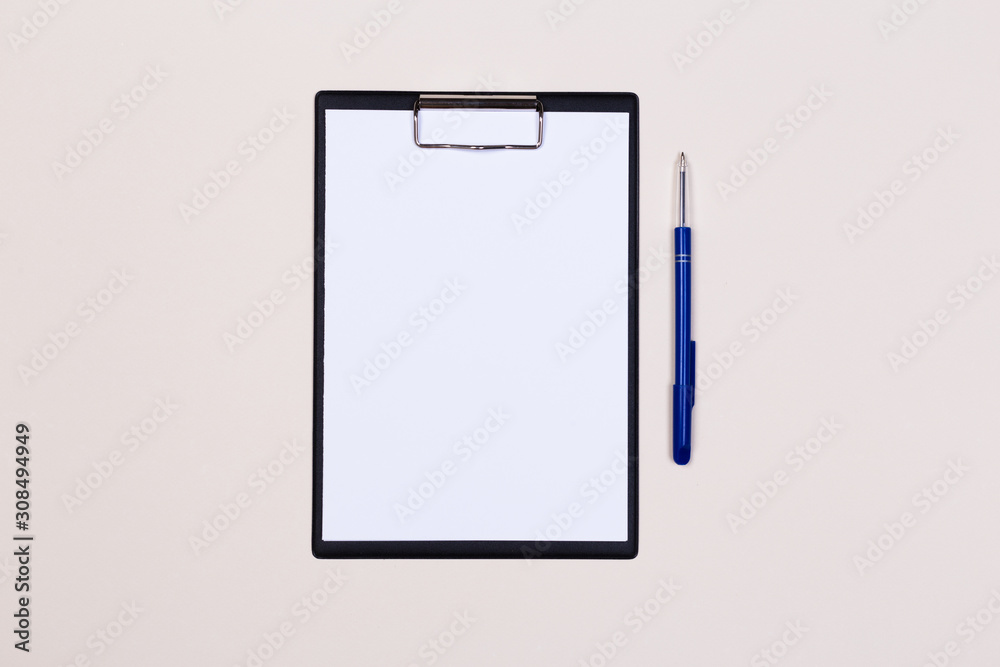 Clipboard with a white sheet and pen on a light background. View from above. space for text Clipboard with a white sheet and pen on a light background. View from above. space for text