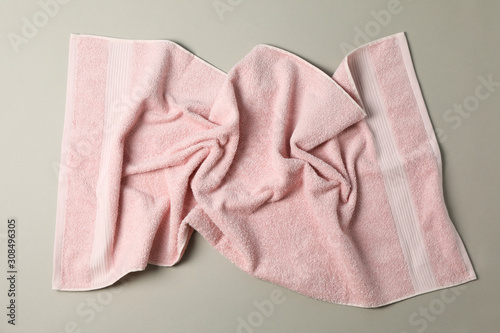 Crumpled pink towel on grey background, top view