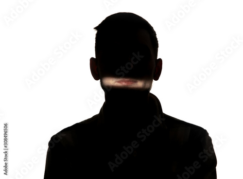 Dramatic portrait of caucasian young man in the dark isolated on white studio background. Sunlight line on the dark face. Human nature, hidden things, psycology concept. Art elegant creative photo.