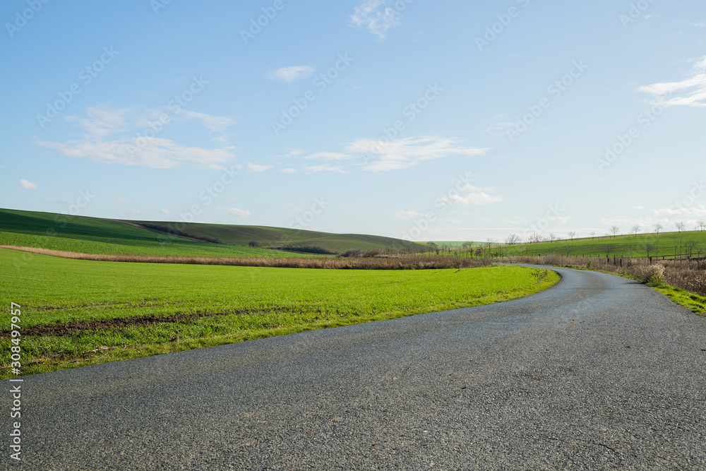 View of the main road leading to vineyards and farms in the Svatoborice region of Moravian Tuscany during a sunny autumn day in the background a blue sky full of clouds. View of the main road leading to vineyards and farms in the Svatoborice region of Moravian Tuscany during a sunny autumn day in the background a blue sky full of clouds.