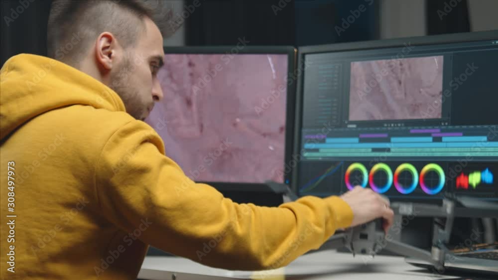 Freelance videographer colorist editing footage using professional