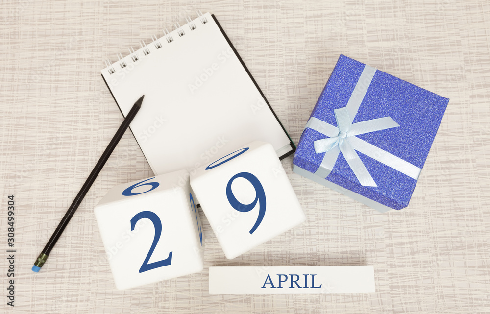 Calendar with trendy blue text and numbers for April 29 and a gift in a box.