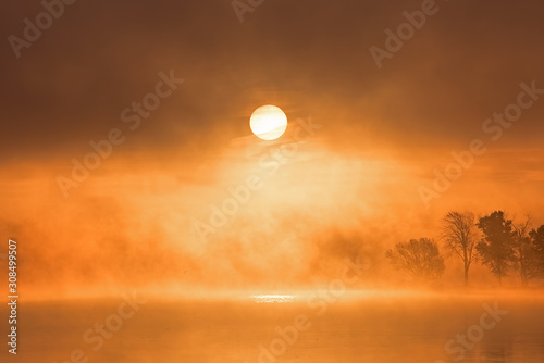 Autumn sunrise in fog Gun Lake, Yankee Springs State Park, Michigan, USA