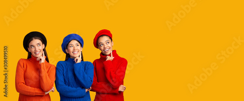 Three Excited Girls Thinking Looking Upward On Yellow Background