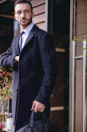 Attentive young bearded businessman beginning his workday