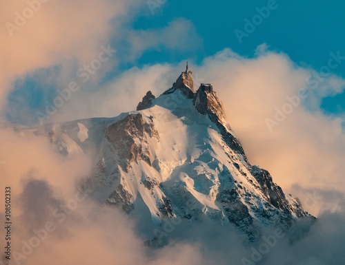 Picture of Aiguille du Midi covered in the snow and the fog under a blue sky in the French Alps