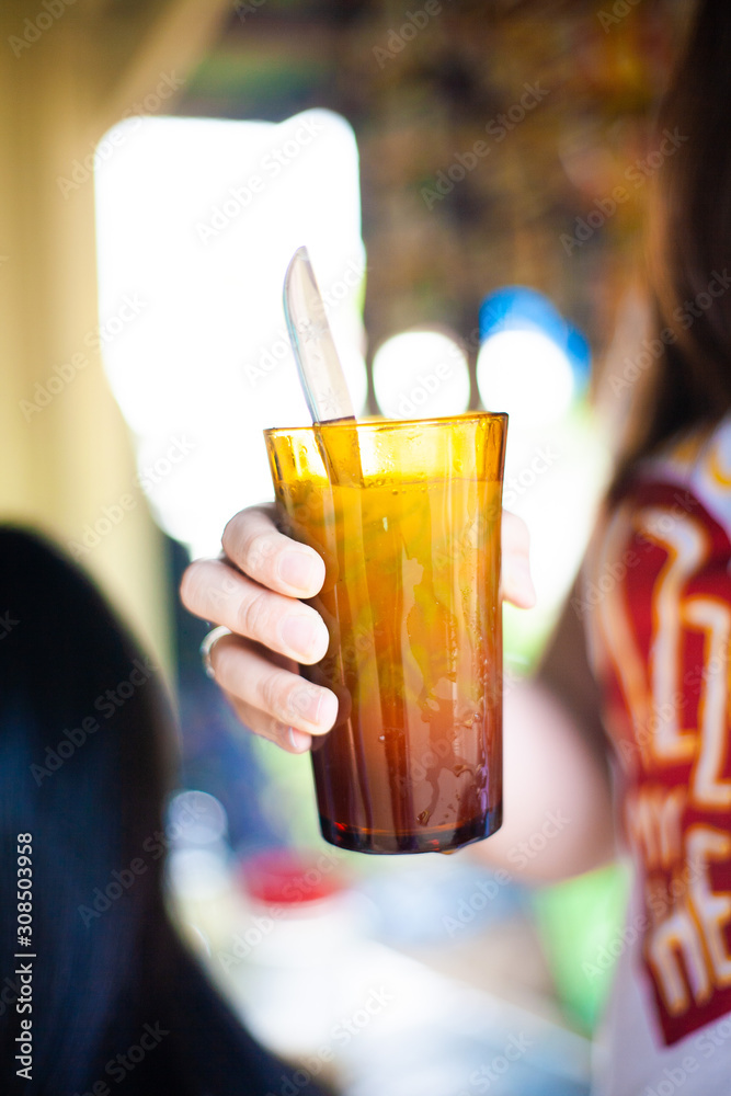 Girl holding onto a glass of ice chendol Girl holding onto a glass of ice chendol