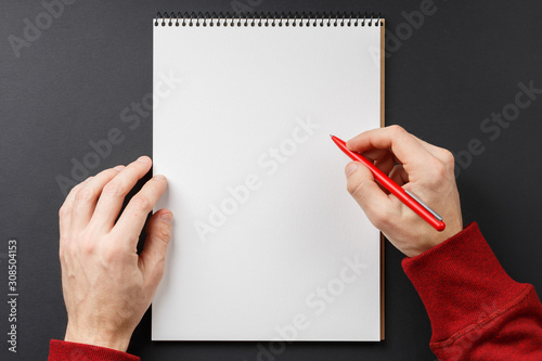 notebook with black pen in hands