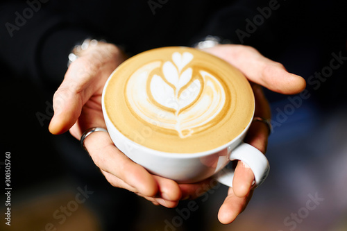 barista holds a white cappuccino mug with beautiful foam