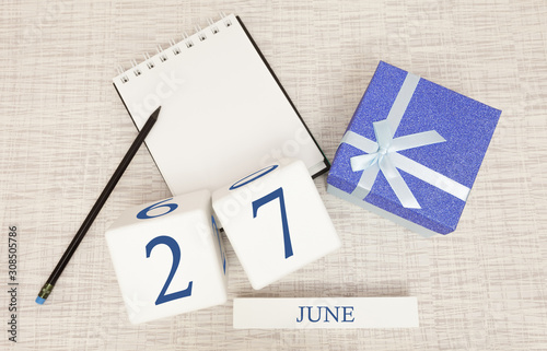 Calendar with trendy blue text and numbers for June 27 and a gift in a box.