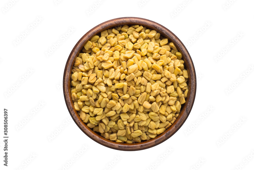 fenugreek seed spice in wooden bowl, isolated on white background. Seasoning top view