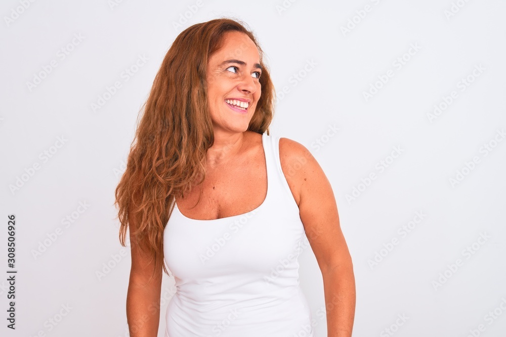 Middle age mature woman standing over white isolated background looking away to side with smile on face, natural expression. Laughing confident. Middle age mature woman standing over white isolated background looking away to side with smile on face, natural expression. Laughing confident.