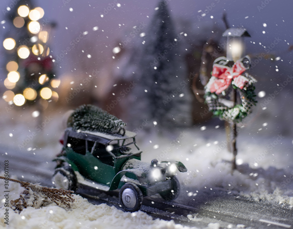 Miniature classic car carrying a christmas tree on winter magic background Miniature classic car carrying a christmas tree on winter magic background