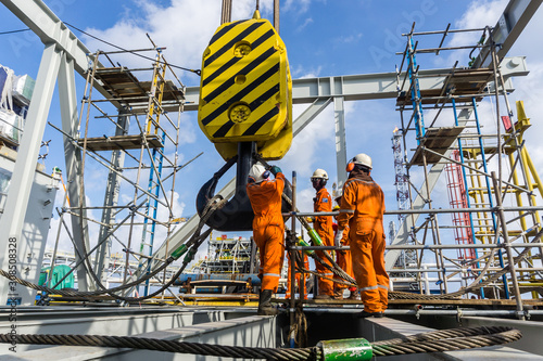 Fototapet Offshore workers performing inspection to a crane hook and rigging arrangement p