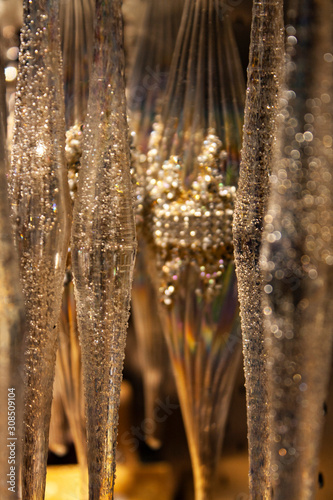 surface of glass artificial icicles hanging in a row that reflect light and rainbow