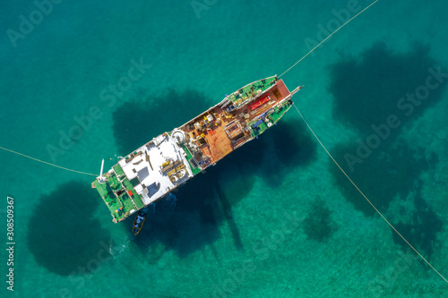 In the middle of the sea is a fishing boat with stretched nets. Close up. The view from the top. © ROMAN DZIUBALO