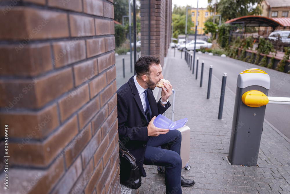Serious bearded man enjoying his tasty sandwich Serious bearded man enjoying his tasty sandwich