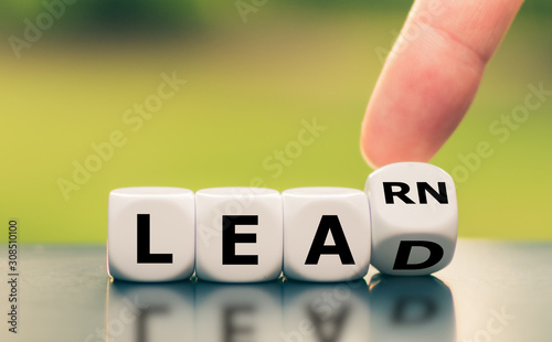 Learn and Lead. Hand turns a dice and changes the word "learn" to "lead".