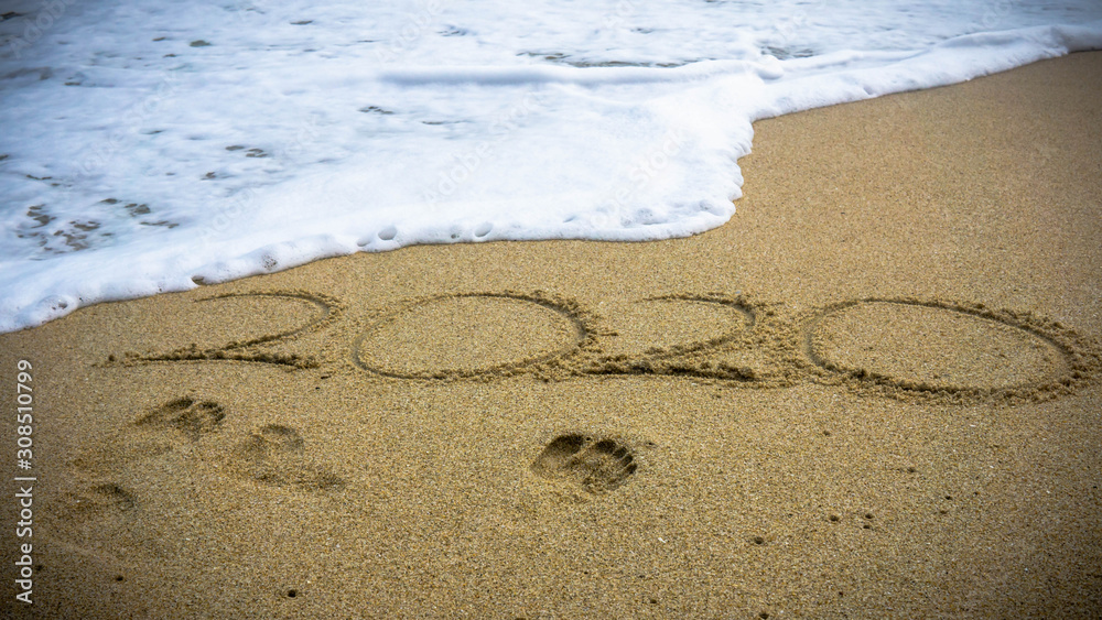 Numbers 2020 year on the sea shore, message handwritten in the golden sand on beautiful beach background. Numbers 2020 year on the sea shore, message handwritten in the golden sand on beautiful beach background.