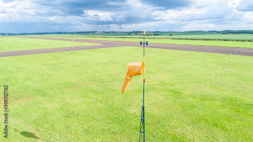 Orange windsock wind sock on the aerodrome, sugar cane plantation background. photo