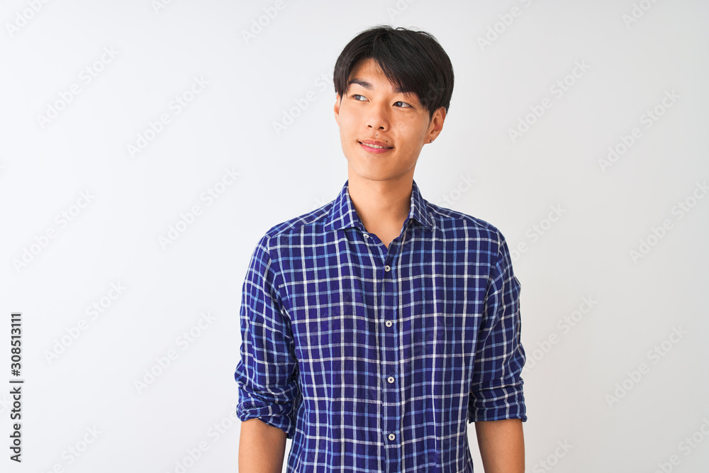 Young chinese man wearing casual blue shirt standing over isolated white background smiling looking to the side and staring away thinking. Young chinese man wearing casual blue shirt standing over isolated white background smiling looking to the side and staring away thinking.