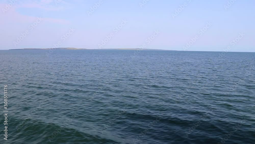 Distant island and open water at Lake Victoria seen from moving ferry Distant island and open water at Lake Victoria seen from moving ferry