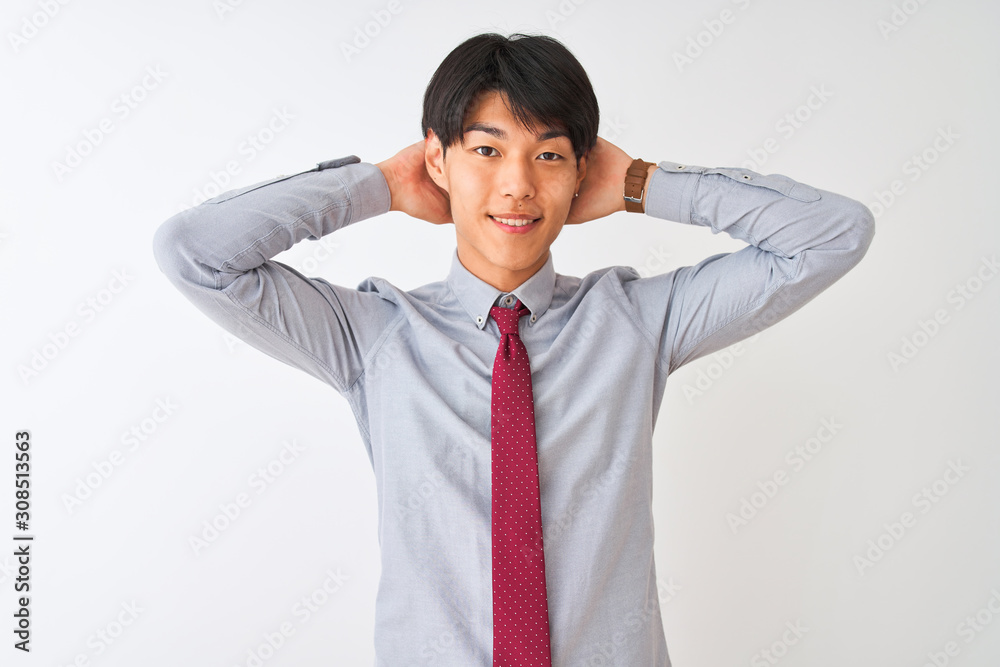 Chinese businessman wearing elegant tie standing over isolated white background relaxing and stretching, arms and hands behind head and neck smiling happy