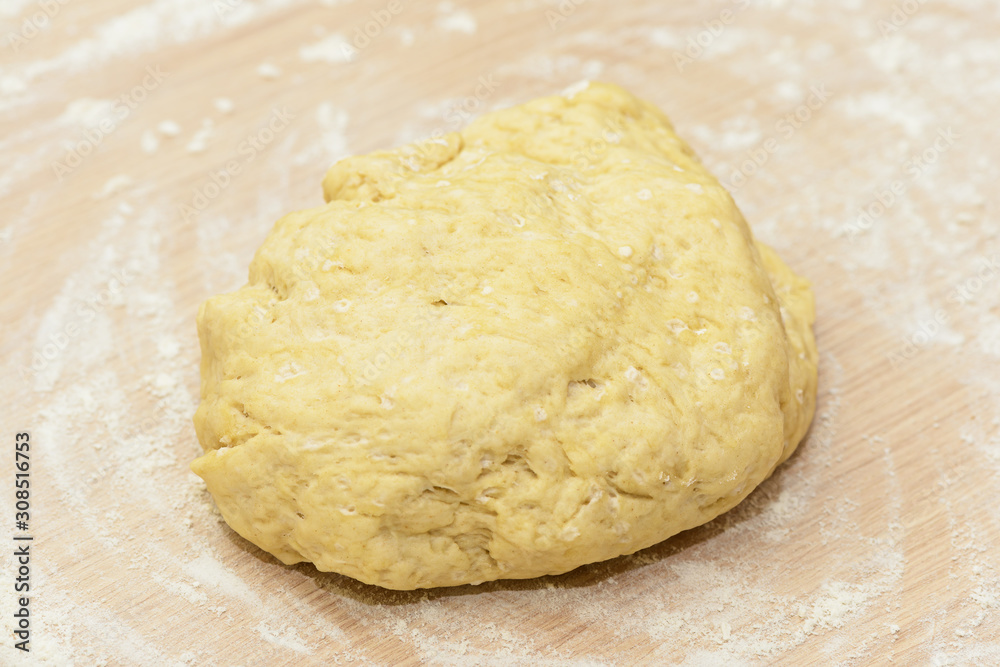 A piece of dough on a table strewn with flour A piece of dough on a table strewn with flour