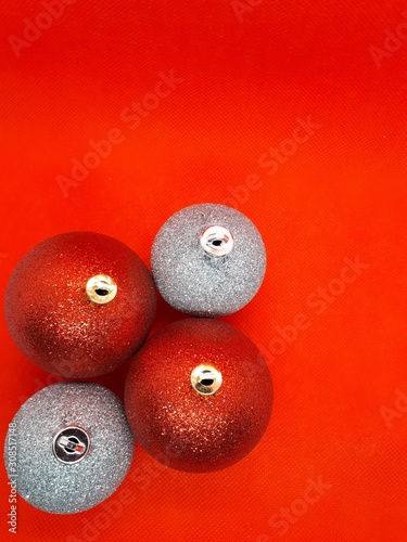  close-up of festive multi-colored ornaments for a Christmas tree, balls and gifts on a bright abstract red background