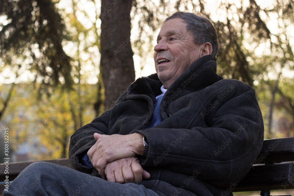Portrait of happy senior man smiling, in the public park, outdoors. Old man relaxing outdoors and looking away. Portrait of elderly man enjoying retirement Portrait of happy senior man smiling, in the public park, outdoors. Old man relaxing outdoors and looking away. Portrait of elderly man enjoying retirement