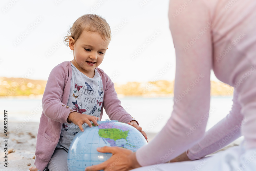 Portrait of little girl looking at Earth beach ball Portrait of little girl looking at Earth beach ball